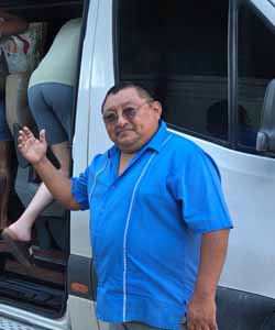 Joaquín, chofer guía de excursiones privadas a Chichén Itzá, posando junto al transporte del tour